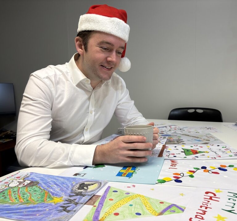 Tom Rutland MP with the entries for his 2025 Christmas card competition.